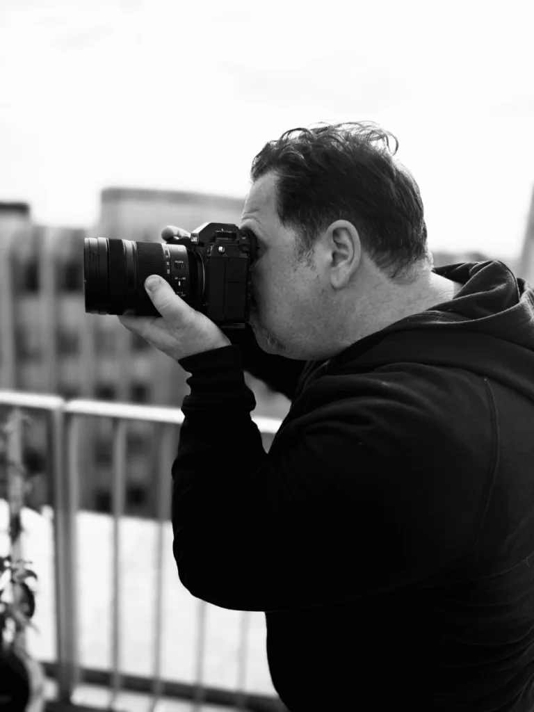 Denis Vila mit Kamera während des Shootings mit Kunde draußen